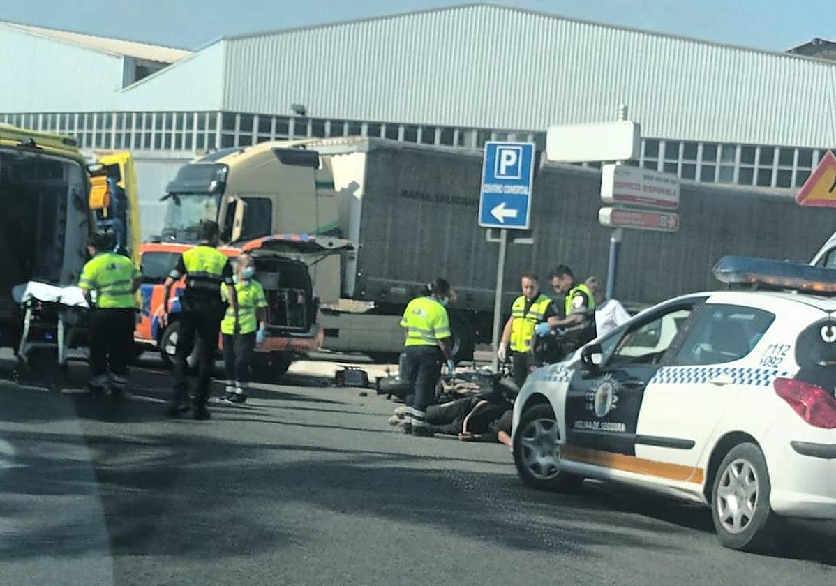 Los sanitarios atienden al motorista, que se encuentra tumbado en el suelo.