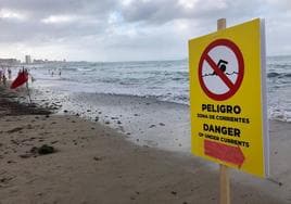 Bandera roja y cartel de advertencia, este jueves, en la playa de Levante.