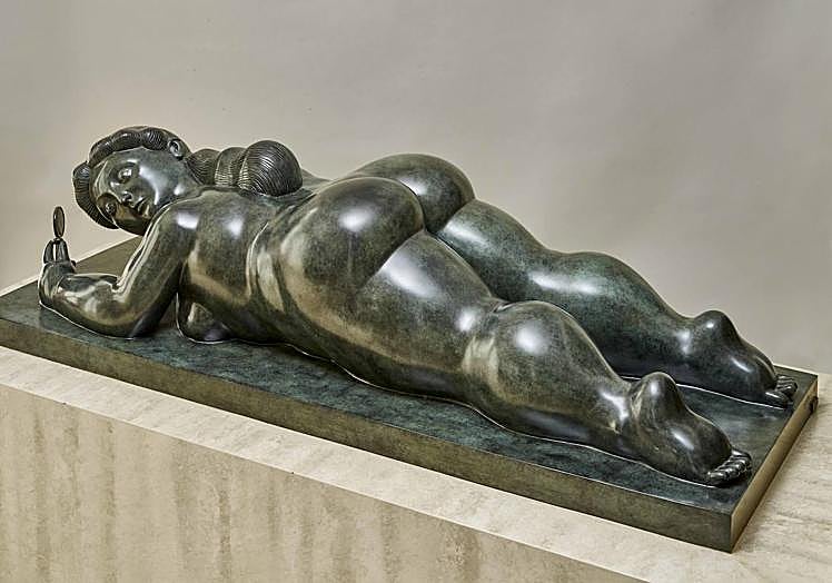 Imagen principal - Escultura en bronce llamada 'Mujer con espejo' (1986), junto a la obra 'Adán y Eva' y un retrato del colombiano en una visita a España.