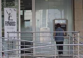 Una persona sacando dinero de un cajero automático, en una imagen de archivo.