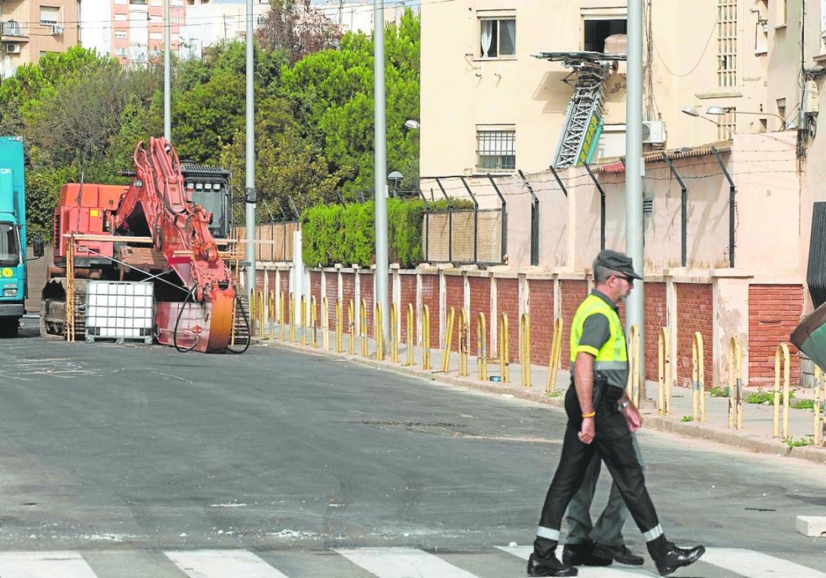 Dos guardias civiles pasan frente a uno de los bloques del cuartel donde una empresa de mudanzas saca enseres de uno de los pisos.