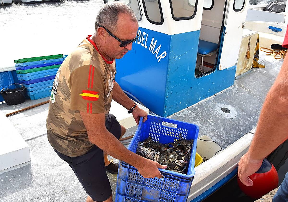 Antonio Jesús López 'El del Estacio', descarga, este jueves, las pocas cajas de pescado del día en el muelle de Lo Pagán.