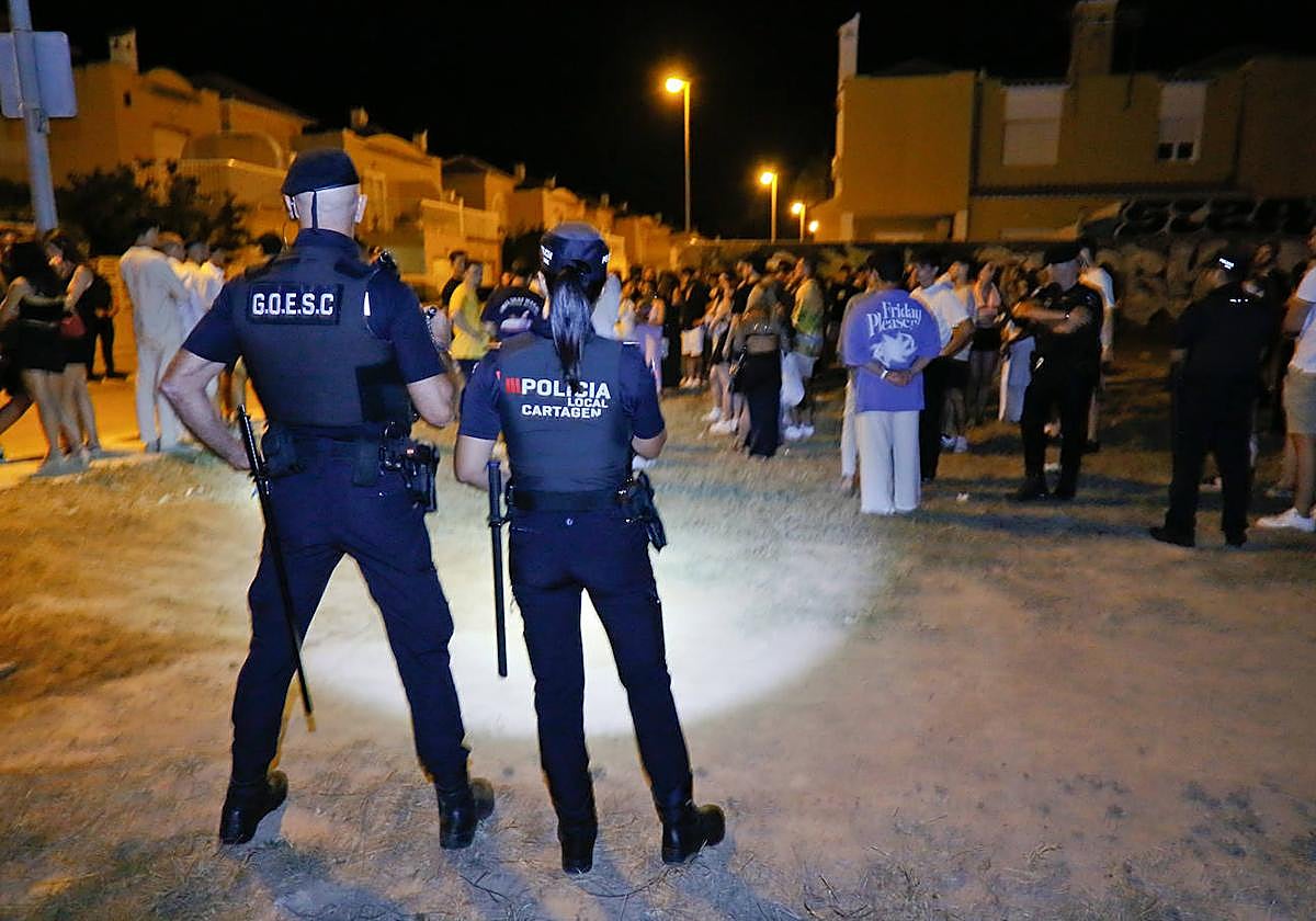 Cuatro agentes de la Policía Local vigilan a un grupo de jóvenes en un solar a la entrada de Cabo de Palos.