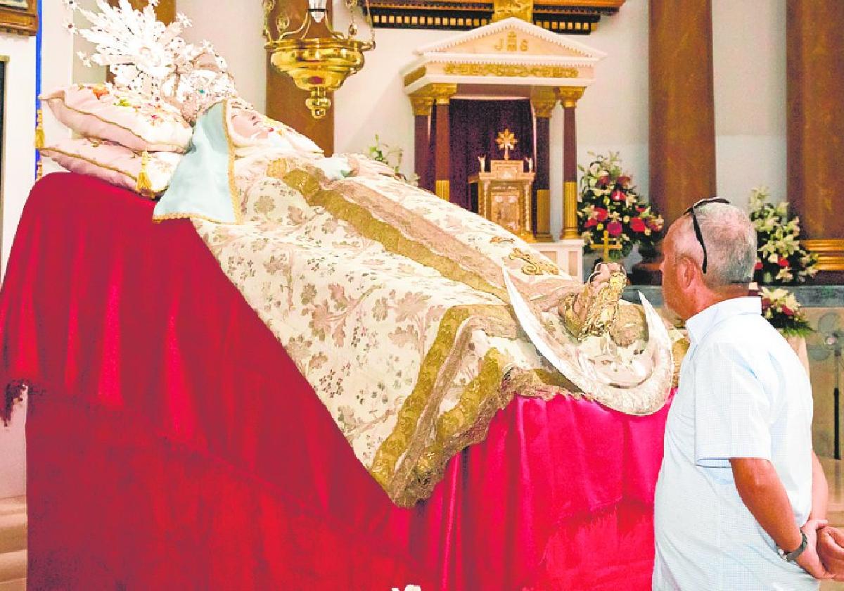 Un devoto se detiene ante el catafalco de la Virgen de la Asunción, en el altar mayor.