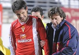 El doctor Salvador Castillo ayuda a abandonar el campo a Pereyra, que se lesionó en un partido del Real Murcia contra el Cádiz.