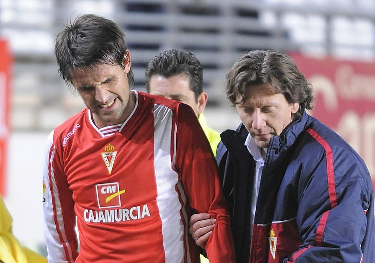 El doctor Salvador Castillo ayuda a abandonar el campo a Pereyra, que se lesionó en un partido del Real Murcia contra el Cádiz.