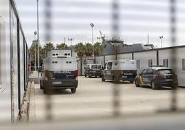 Furgones de la Policía Nacional custodian a inmigrantes llegados al CATE del Puerto de Cartagena.