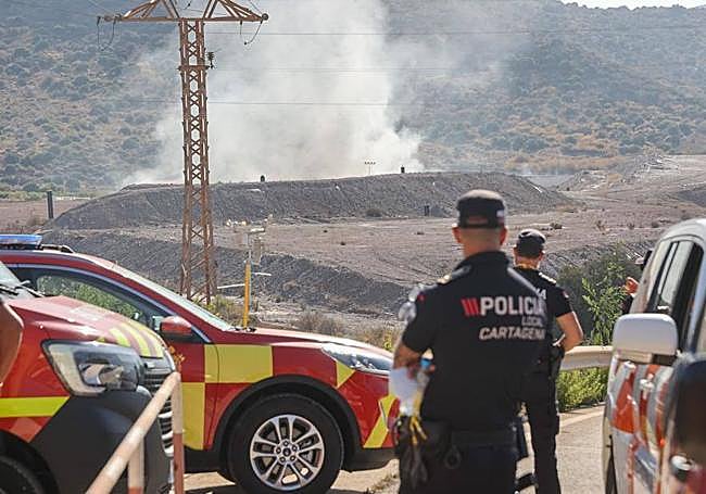 Agentes de la Policía vigilan que ningún vehículo circule por la carretera cortada que comunica con la nave incendiada.