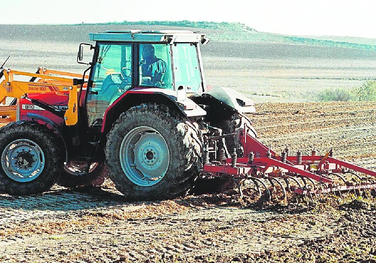 Un tractor labra una parcela recién arrendada.