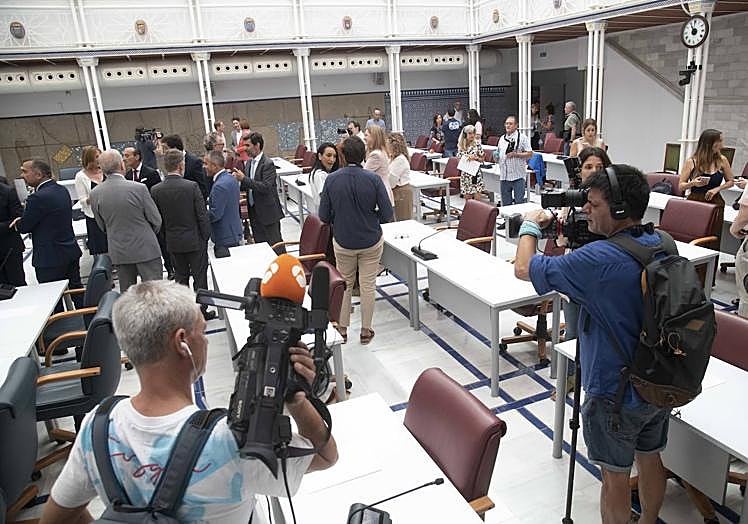 Imagen principal - Los diputados charlan entre ellos antes del inicio de la sesión; invitados en la sala habilitada para presenciar el debate de investidura y parlamentarios prestan atención a la intervención de López Miras. 