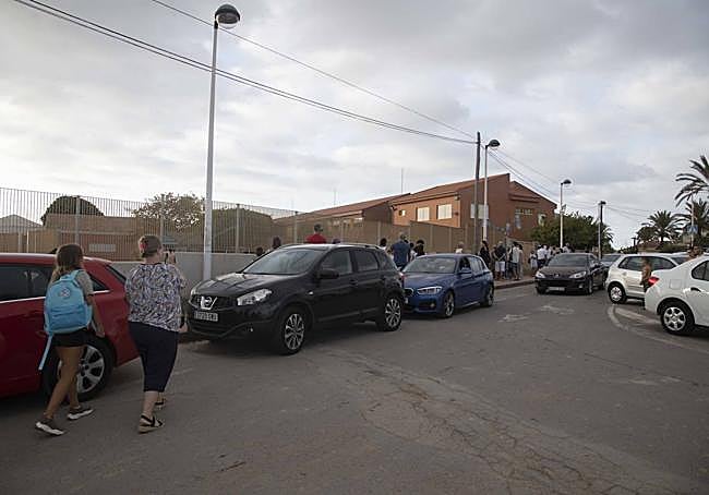 Coches aparcados a la puerta del colegio Mediterráneo de La Manga, uno de los afectados por la falta de rutas.