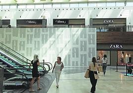Varias personas pasan frente a las obras que realiza Zara en su nuevo local en Espacio Mediterráneo.
