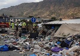 Bomberos trabajan en la zona donde volcó el camión de basura, en Alhama.
