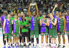 Los jugadores de Unicaja levantan la copa de campeones del Trofeo Costa del Sol que ganaron ante el Real Madrid el pasado domingo.