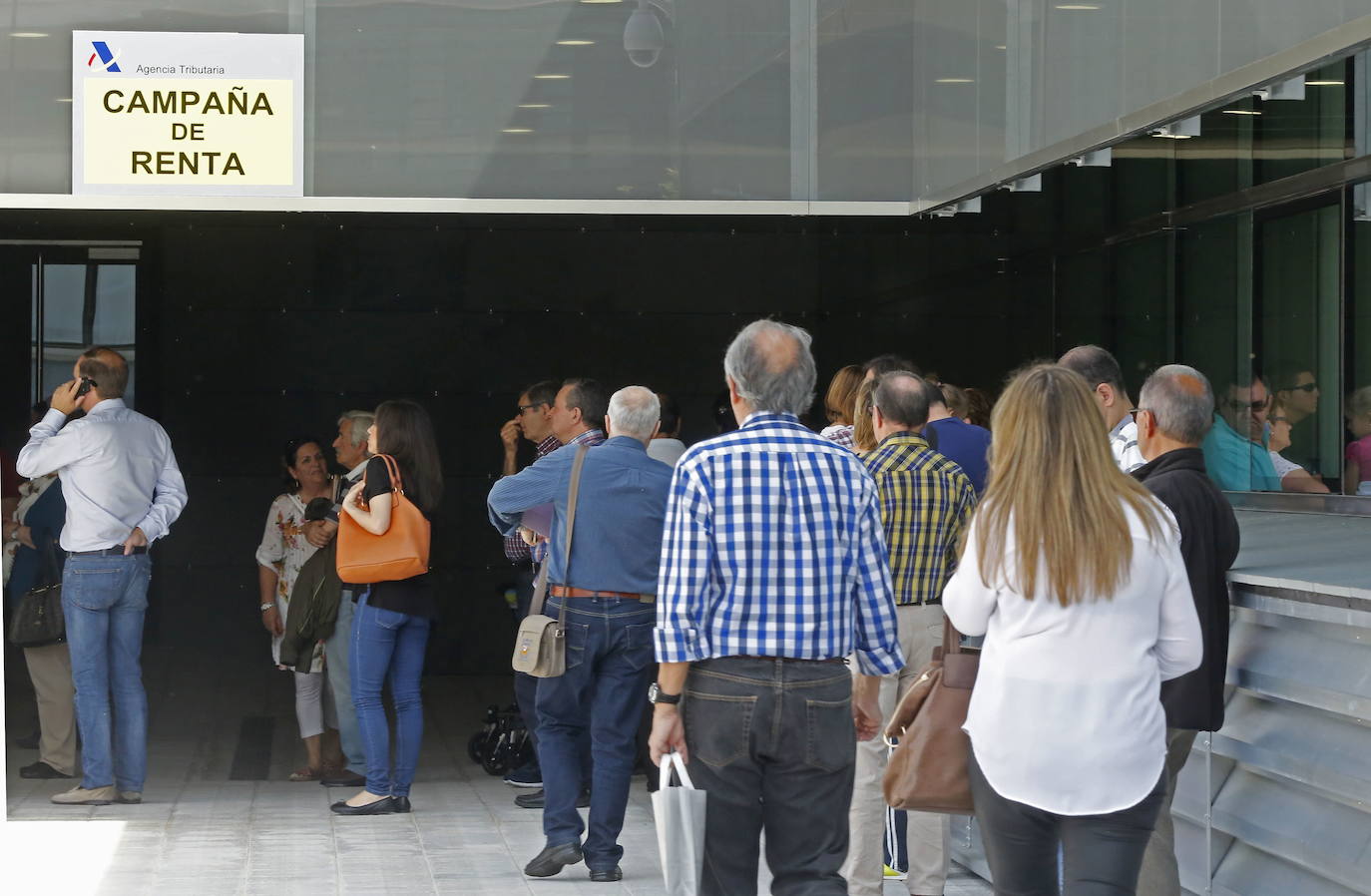 Numerosas personas hacen cola en una sede de la Agencia Tributaria durante la campaña de la Renta, en una imagen de archivo.