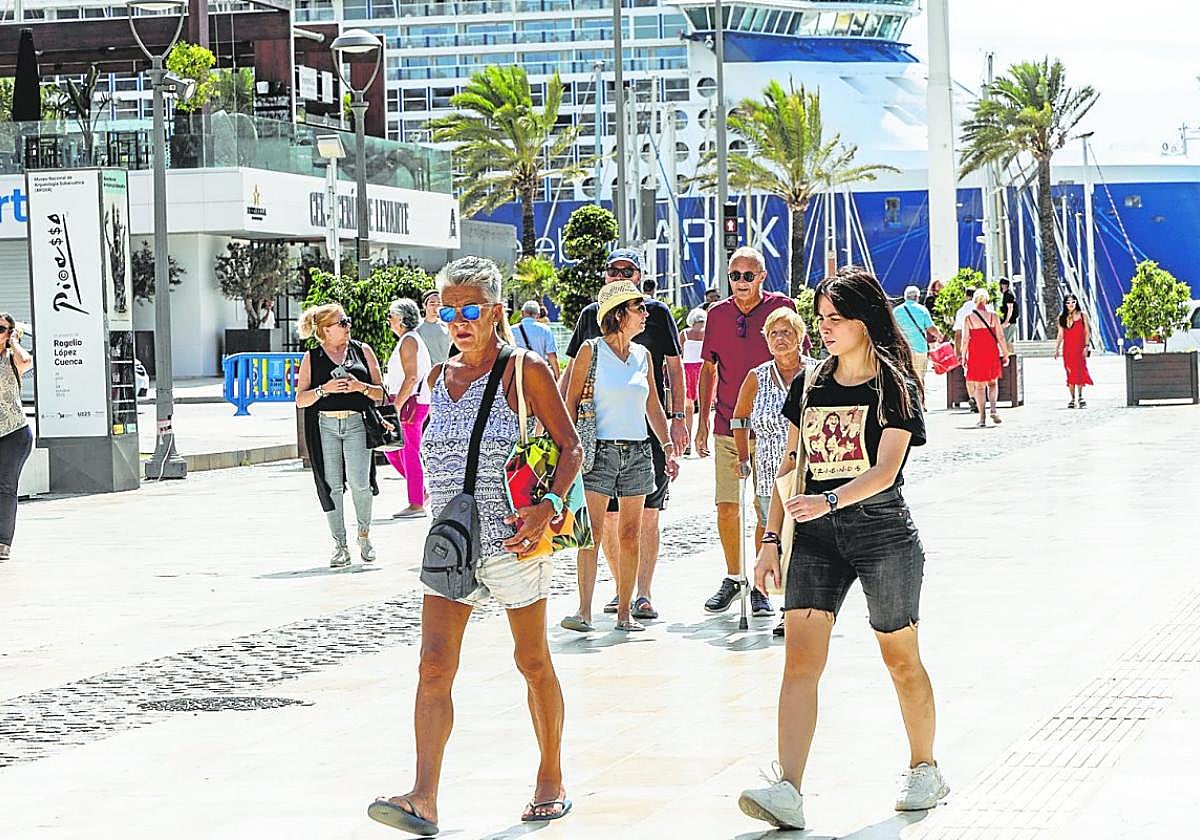 Turistas paseando por la Plaza Héroes de Cavite, ayer, y al fondo, el crucero 'Celebrity Apex', en el muelle Juan Sebastián Elcano.