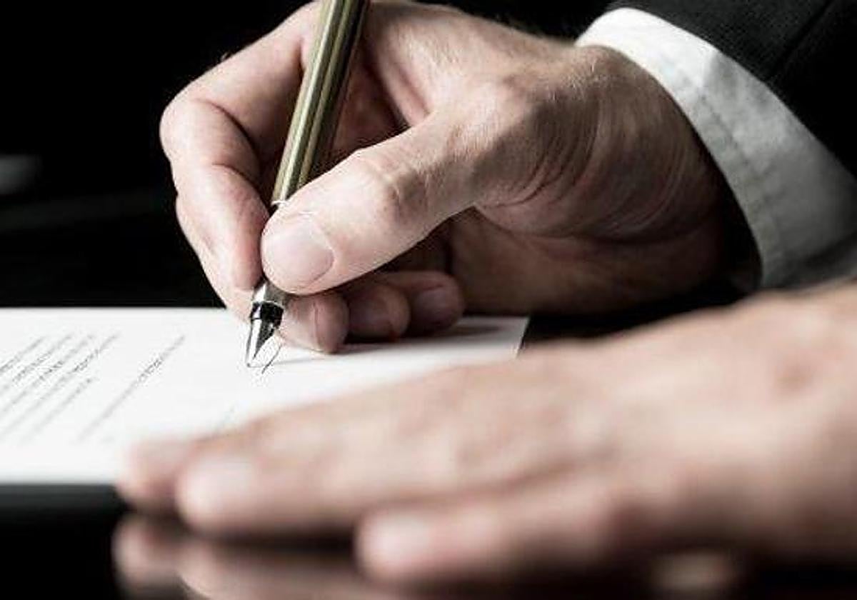 Un hombre firma un testamento en una imagen de archivo.