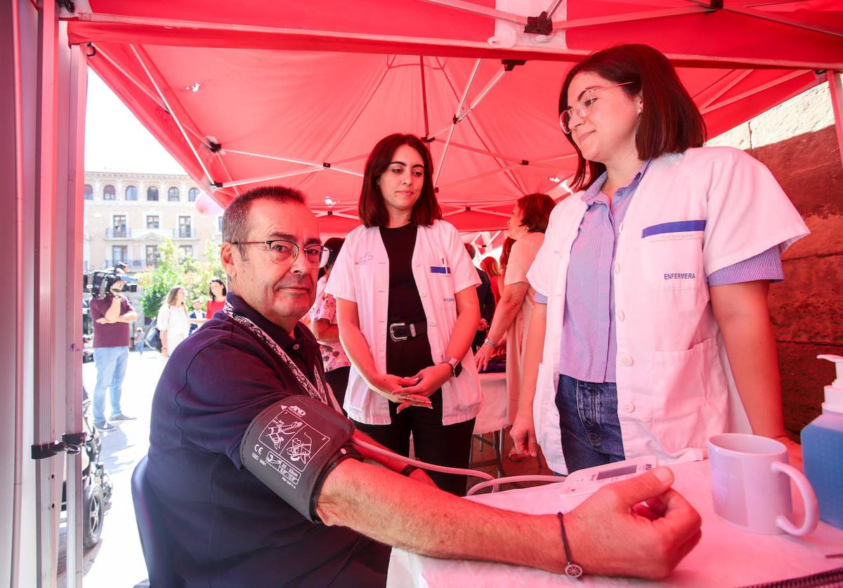 Las enfermeras María Jódar y Cristina Martínez toman la tensión a Francisco Javier Ortiz, ayer, en la carpa que el Proyecto Pharaon instaló junto a diversas organizaciones en Santo Domingo, en Murcia, con motivo del Día Mundial del Corazón.