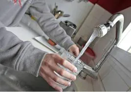 Una persona bebe agua del grifo de su vivienda.
