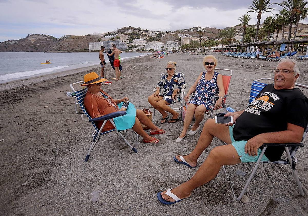 Cuatro personas mayores disfrutan de la playa.