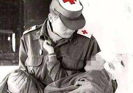 Un voluntario de Cruz Roja atiende a un niño herido en un accidente.