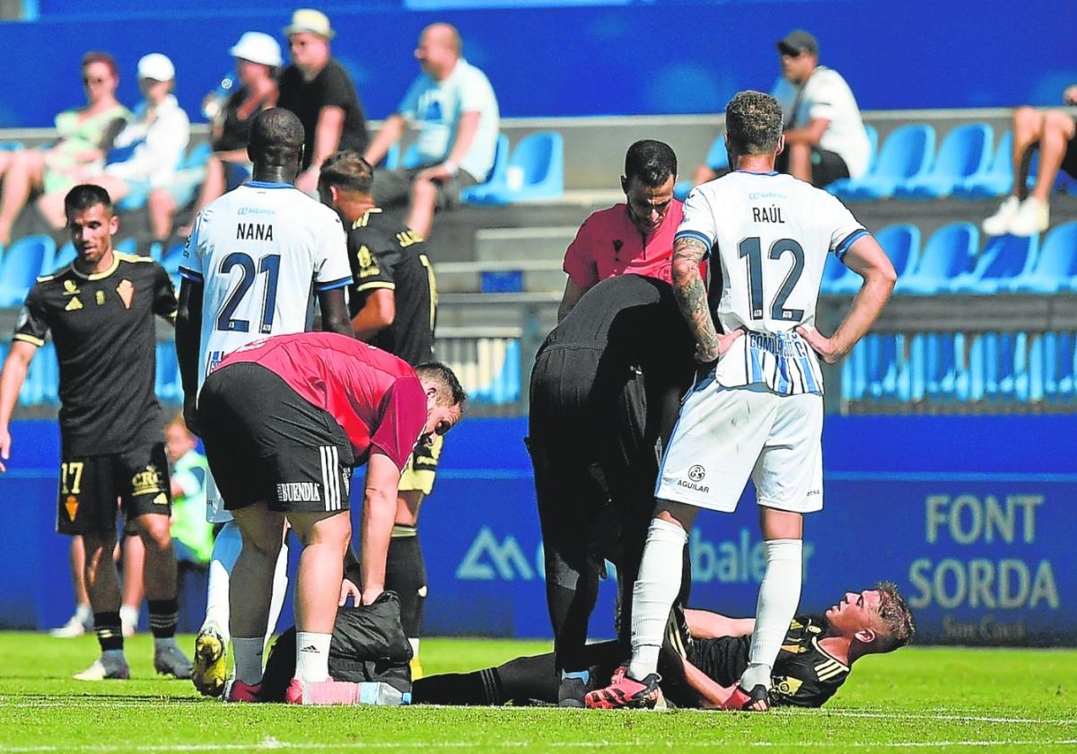 Álex Rubio, sobre el césped, recibe asistencia técnica en el duelo ante el Baleares disputado el pasado domingo.