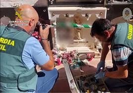 Agentes inspeccionando una de las tumbas asaltadas.