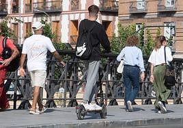 Un joven circulan en patinete por una acera en Murcia, este viernes.