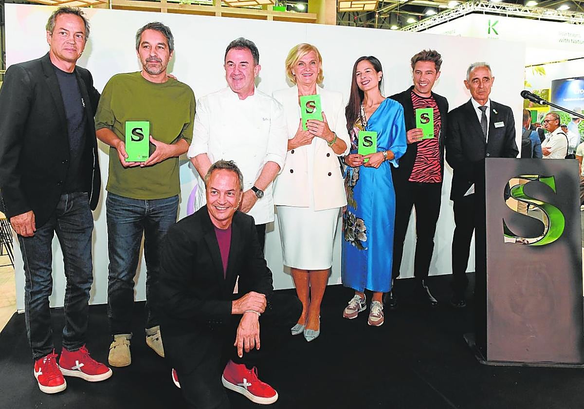 Foto de familia de los premiados. A la derecha, estand de Sakata.