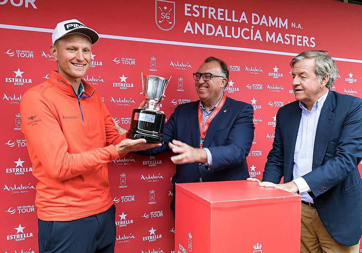 El campeón Meronk recibe la copa de manos del consejero de Turismo, Cultura y Deporte de la Junta de Andalucía, Arturo Bernal (c)