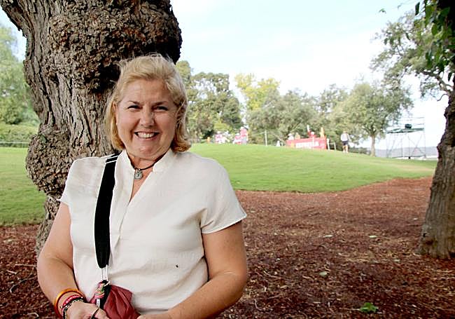Esther sonriendo mientras sigue a su hijo a cierta distancia.