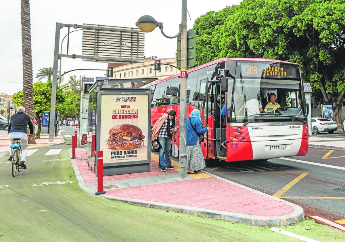 Varios pasajeros toman un autobús de la Línea 30, en dirección a Zeneta, en la nueva parada frente al Hospital Reina Sofía.