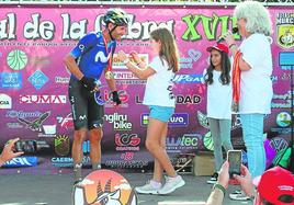 Una niña pone la medalla de ganador a Alejandro Valverde.
