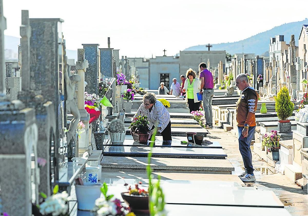 Varias personas limpian las lápidas en el cementerio de San Antón, esta semana.