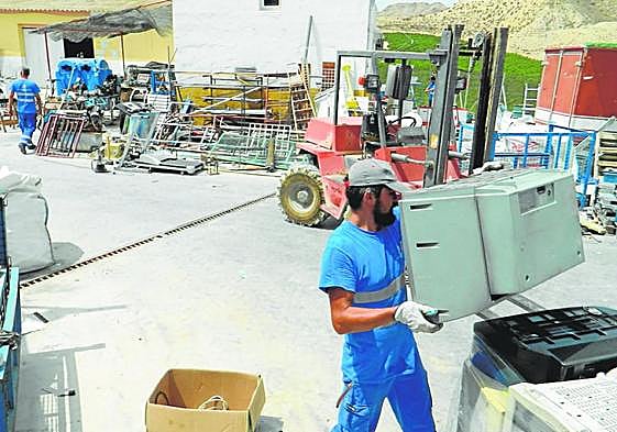 Empleados de Traperos trasladan enseres en el centro de recuperación.