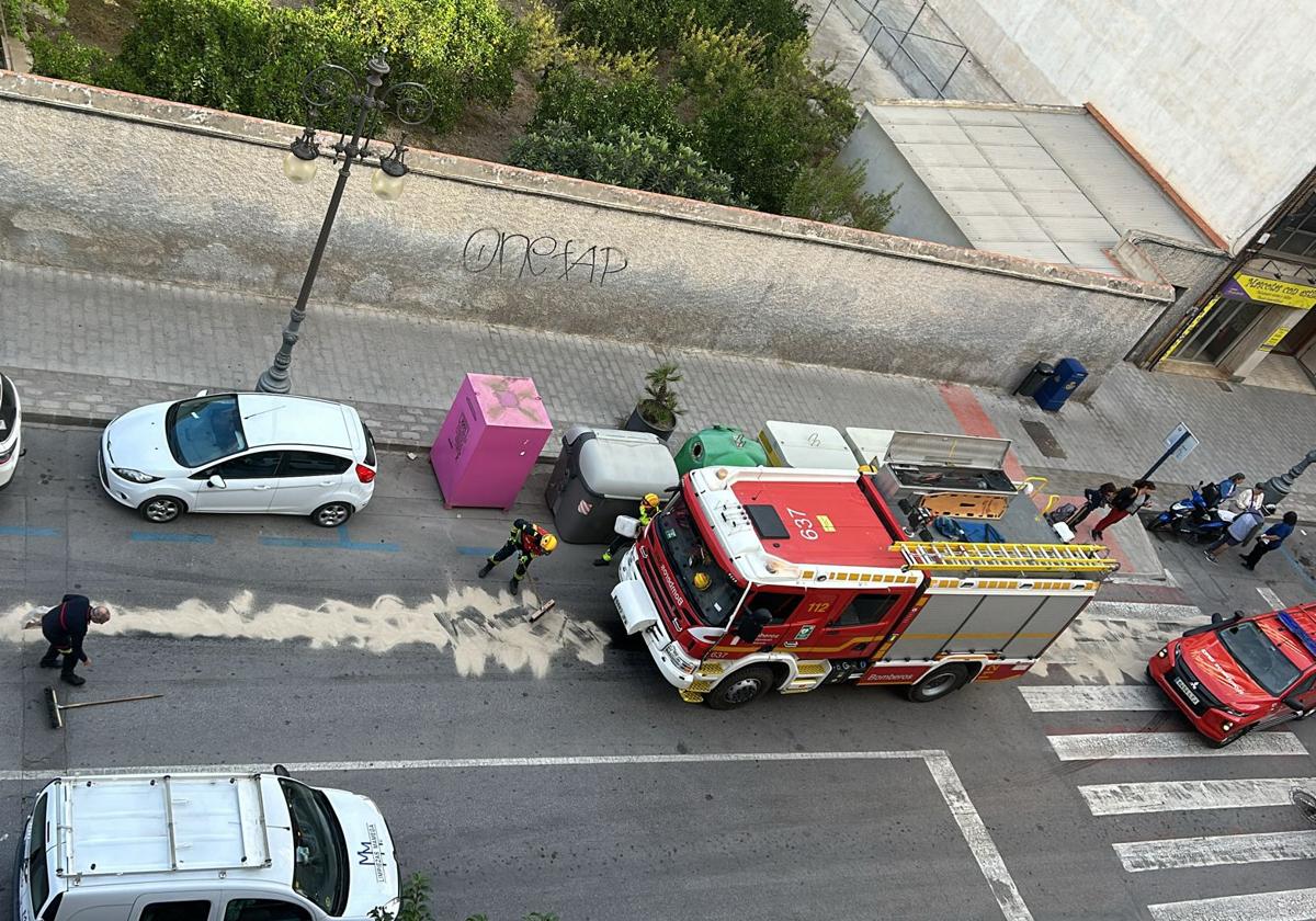Los Bomberos esparcen sepiolita por la avenida.