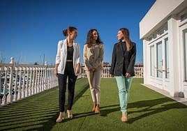 Beatriz, Mireya y Paula caminan por la terraza de la Oficina de Turismo, con vistas a las Eras de la Sal y la bahía portuaria.