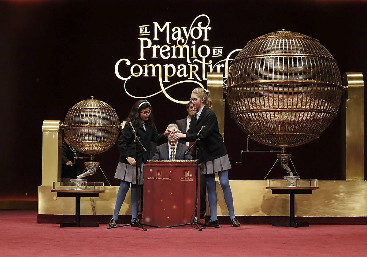 Momento del sorteo de la Lotería de Navidad en el que dos niñas de San Ildefonso extraen dos bolas y las colocan en los alambres de la tabla