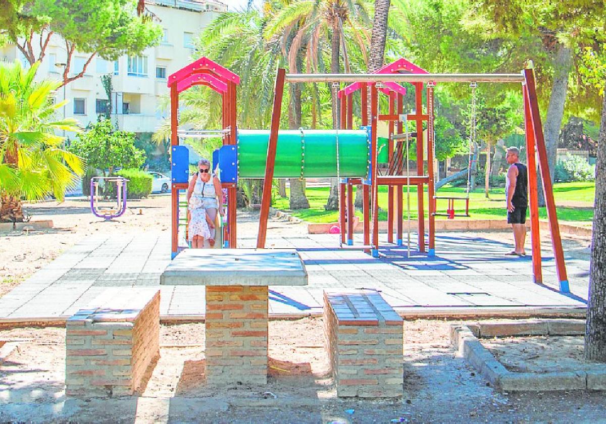 Vecinos pasean por un parque en la urbanización La Zenia.