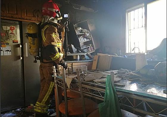 Un bombero en la vivienda incendiada este miércoles en Lorca.
