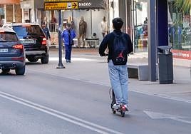 Un joven circula en patinete eléctrico por la avenida Juan Carlos I.