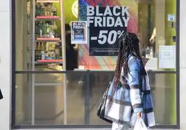 Imagen de archivo de una mujer paseando por delante de un escaparate con el cartel de Black Friday en el centro de Murcia.