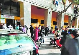 Grupos de personas haciendo cola para recoger alimentos en El Buen Samarinato, en una foto de archivo.