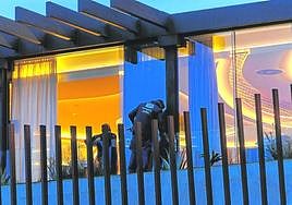 Dos trabajadores limpian cristales, el lunes por la tarde, del edificio gastronómico.