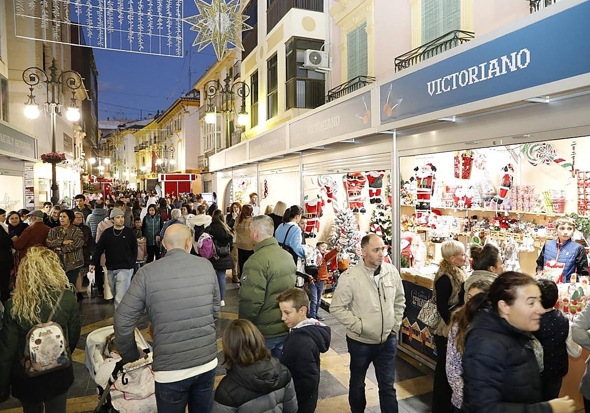 Calle Corredera repleta de gente durante la celebración del primer mercadillo navideño.