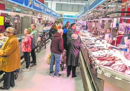 Clientes observando los mostradores de varias pescaderías en el mercado Santa Florentina.