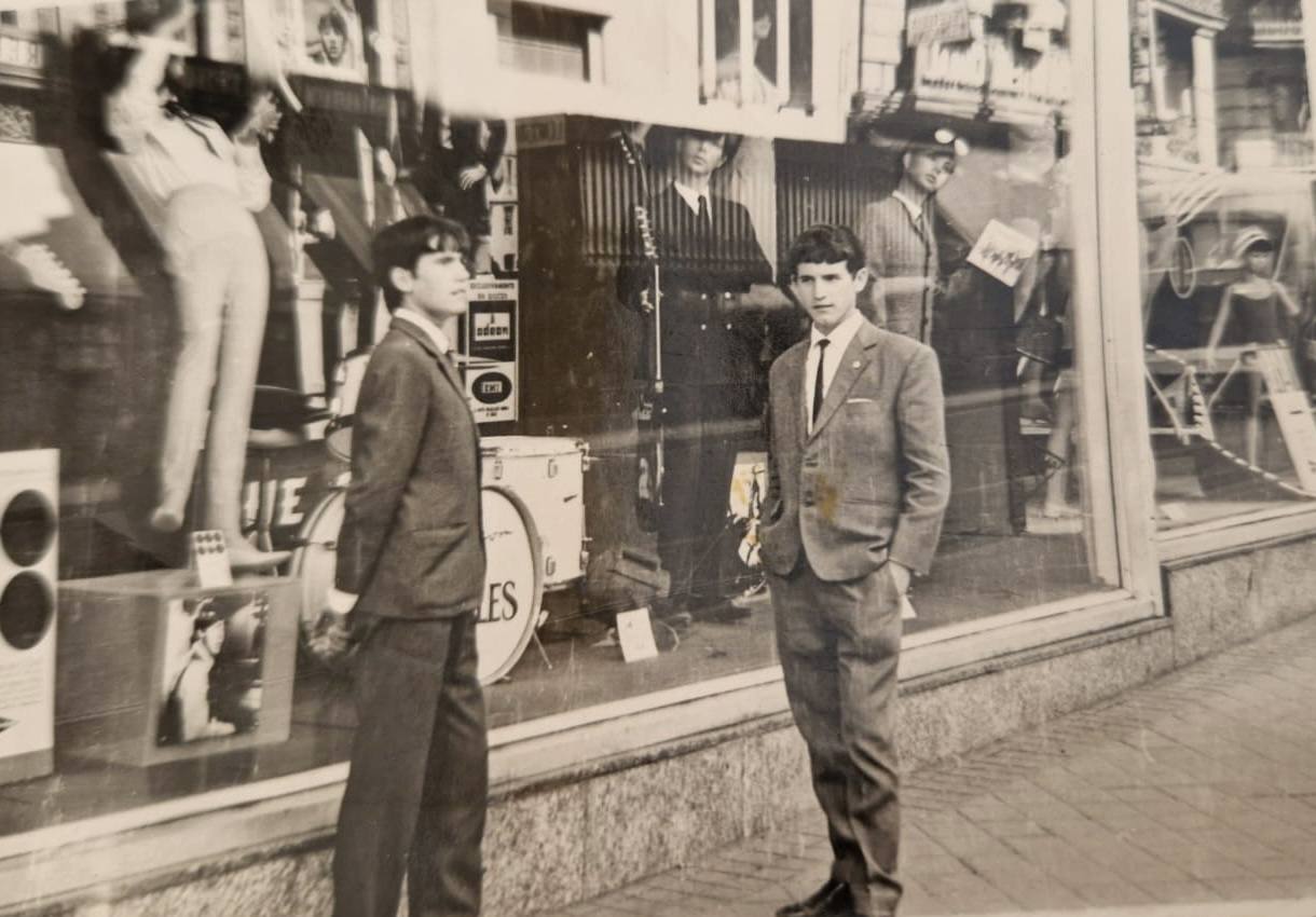 Los hermanos Alfredo y Richar Marín, en Madrid, delante de un escaparate dedicado a Los Beatles.