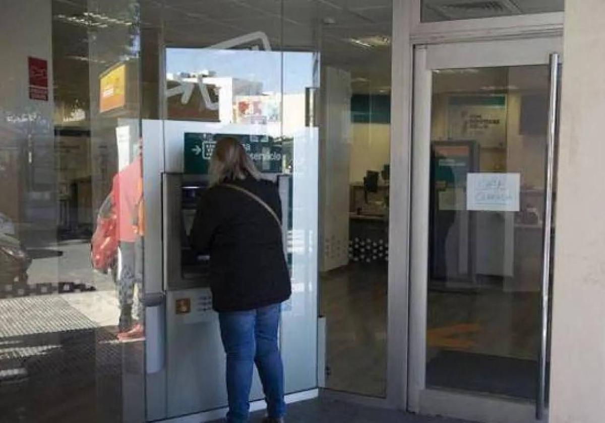 Una mujer saca dinero de un cajero, en una imagen de archivo.