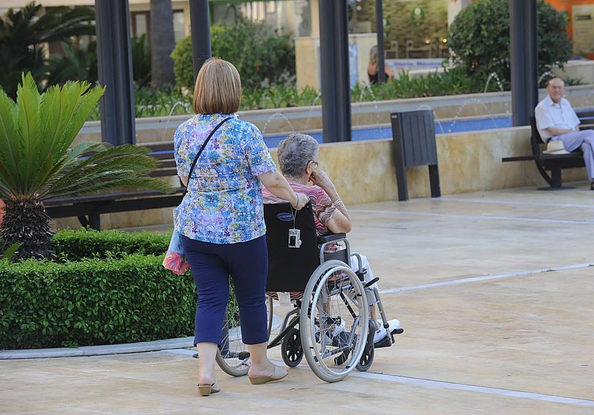 Una mujer ayuda a una persona dependiente en una imagen de archivo.