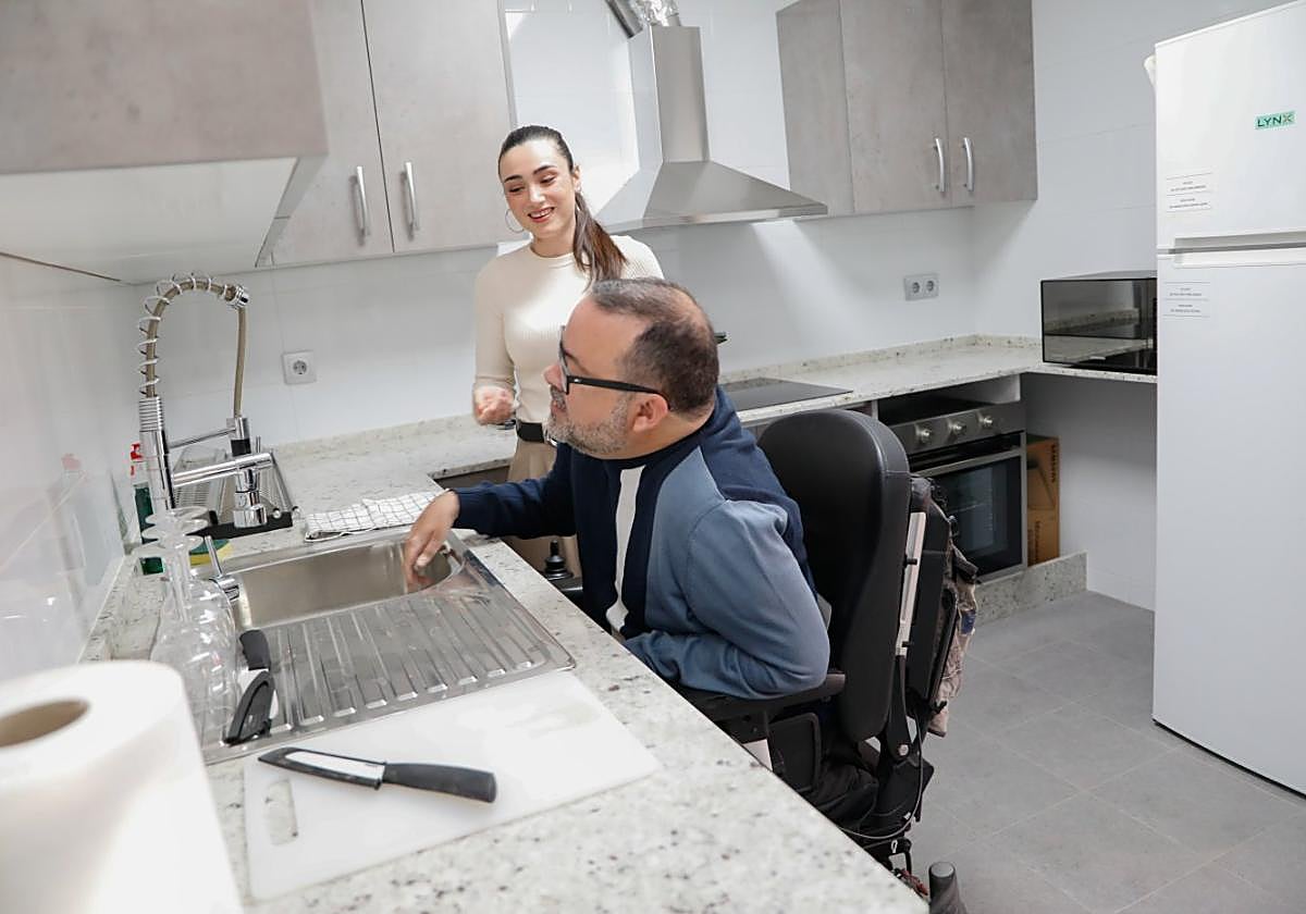 José Luis Llamas en la cocina adaptada del piso junto a la trabajadora social Ana Belén Romera.